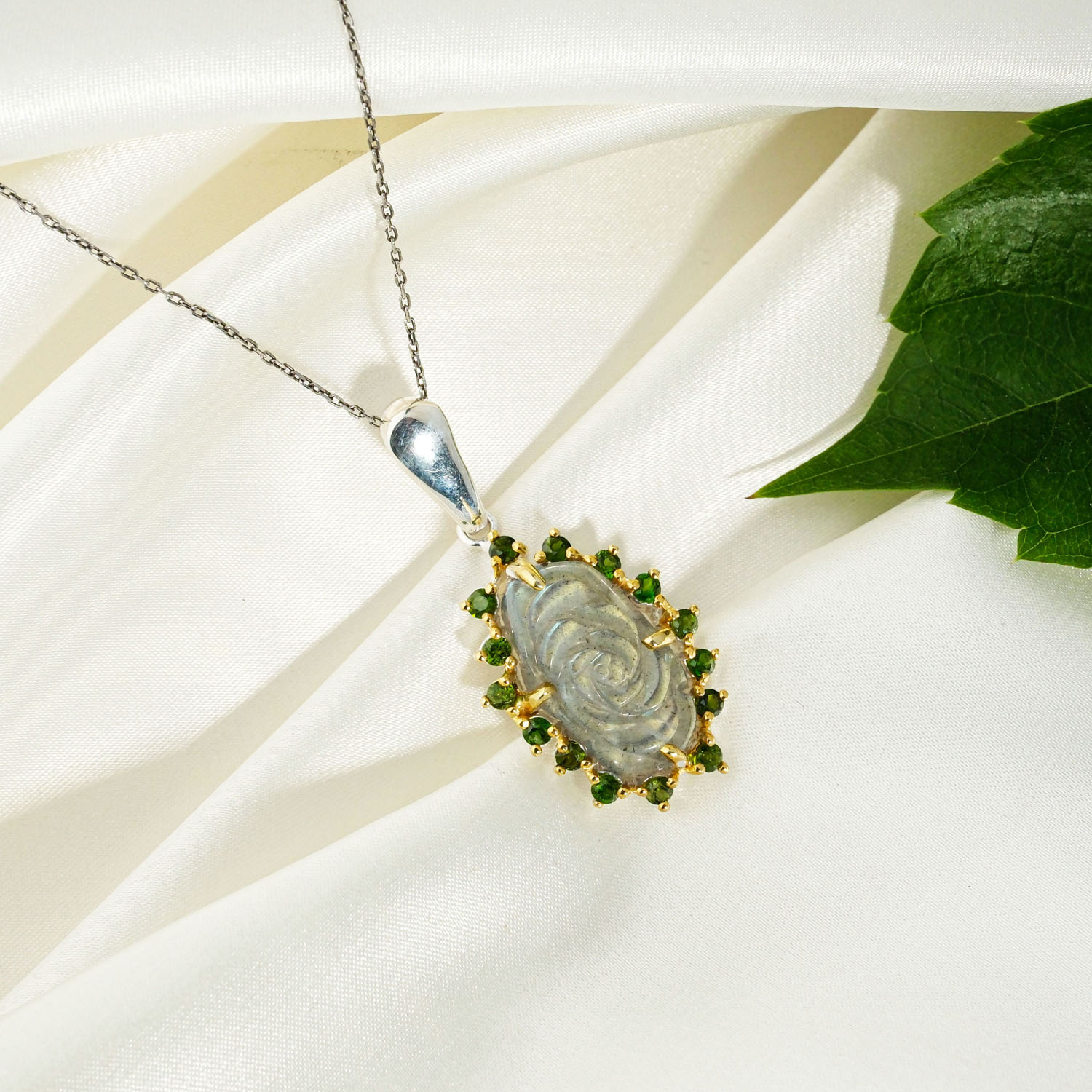 pendentif-femme-rose-labradorite-sculptee-diopside-argent-925 A 925 sterling silver women's pendant featuring a hand-carved labradorite rose gemstone surrounded by green chrome diopside halo.