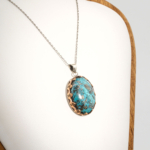 A 925 sterling silver handmade unisex pendant featuring a natural high oval cabochon cut Nishapur turquoise gemstone with heavy pyrite matrix.