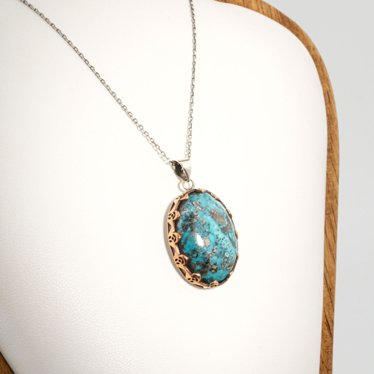 A 925 sterling silver handmade unisex pendant featuring a natural high oval cabochon cut Nishapur turquoise gemstone with heavy pyrite matrix.