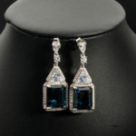Boucles d'oreilles pendantes en argent 925 rhodié avec topaze London Blue naturelle 12ct et zircons trillons.