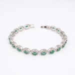 Bracelet de haute joaillerie pour femme en argent 925 rhodié serti d'émeraudes vertes naturelles et halo de zircons.
