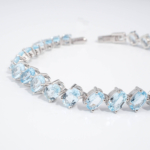 Bracelet de haute joaillerie en argent 925 rhodié avec topazes bleues naturelles ovales en ligne tennis.