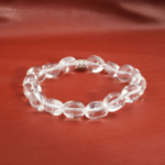 Bracelet élastique en galets polis de cristal de quartz transparent naturel et intercalaire fleur.
