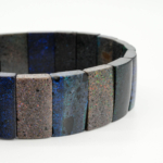 An authentic natural Australian black matrix opal play of color rolex cut beaded stretch bracelet.