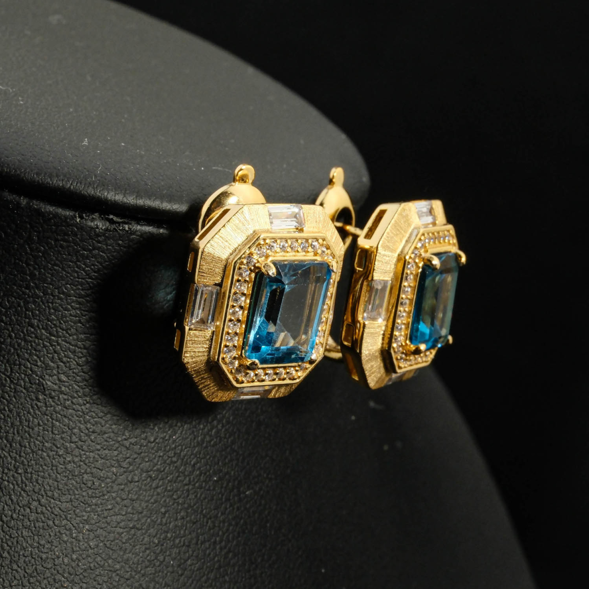 An authentic natural emerald-cut Swiss blue topaz gemstone 14k gold plated 925 silver brushed matte halo stud earrings.