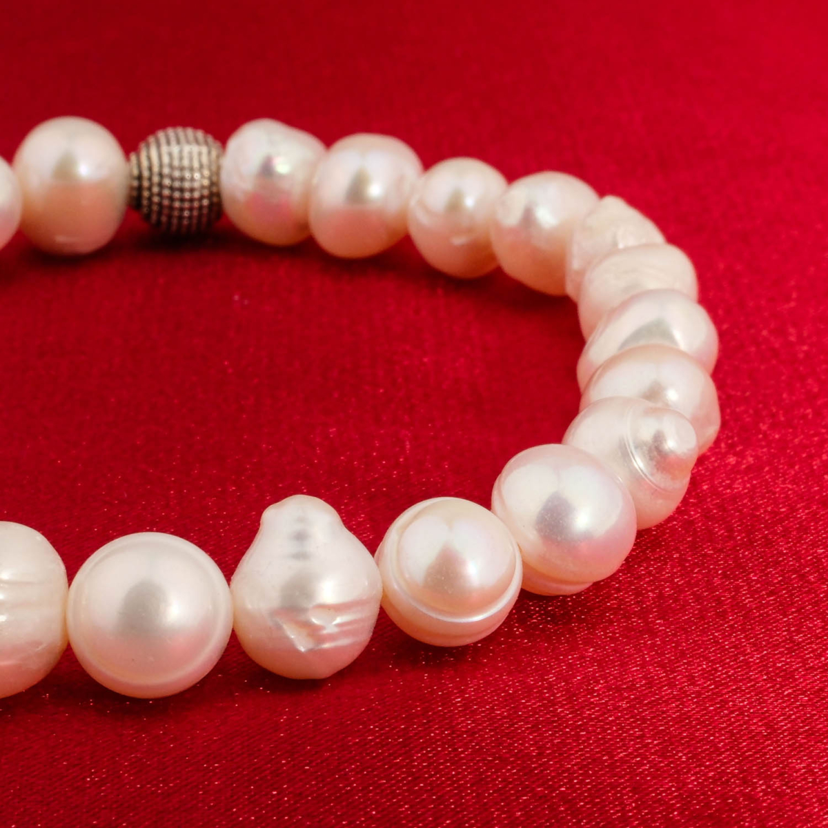 An authentic natural white freshwater pearl beaded stretch bracelet with silver textured metal bead.
