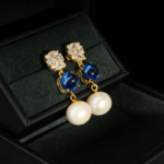 A pair of 925 gold-plated silver stud dangle earrings featuring blue kyanite cabochons and natural ocean pearls.