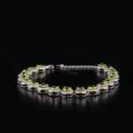 An authentic natural olive green peridot gemstone round faceted zircon halo 925 sterling silver tennis bracelet.