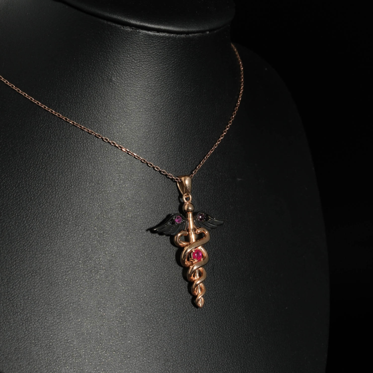 An authentic 0.20ct natural red ruby gemstone Caduceus medical symbol rose gold plated 925 silver pendant necklace.