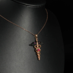 An authentic 0.20ct natural red ruby gemstone Caduceus medical symbol rose gold plated 925 silver pendant necklace.