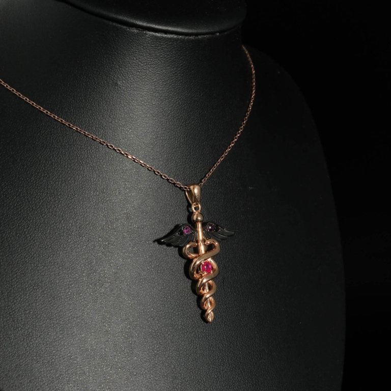 An authentic 0.20ct natural red ruby gemstone Caduceus medical symbol rose gold plated 925 silver pendant necklace.