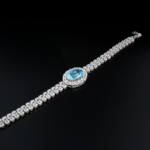 An authentic natural faceted oval Swiss blue topaz gemstone 925 sterling silver luxury halo tennis bracelet.