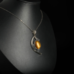 An authentic 14ct natural oval cabochon tiger eye gemstone crescent eye design 925 sterling silver pendant necklace.