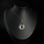Pendentif artisanal en argent 925 oxydé en forme de cadenas avec grenat rouge naturel taille baguette et gravures faites main.
