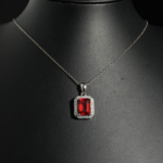 Pendentif de joaillerie en argent 925 rhodié avec grenat hessonite rouge naturel taille baguette et halo de zircons.