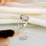 Bague royale pour femme en argent 925 avec aigue-marine naturelle et halo de grenats baguettes sur satin blanc.