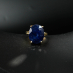 Bague solitaire féminine en argent 925 plaqué or ornée d'un saphir bleu nuit naturel taille ovale facettée.