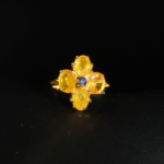 Bague florale d'exception en argent 925 plaqué or ornée de saphirs jaunes naturels et d'un saphir bleu central sur fond blanc.
