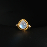 Bague vintage pour femme en argent 925 doré avec pierre de lune naturelle forme goutte sur satin blanc.