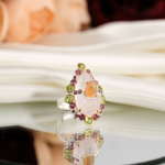Bague royale pour femme en argent 925 avec quartz rose à facettes, opale, péridot et tourmaline rubellite sur velours rouge.