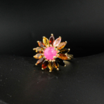 Bague fleur de luxe pour femme en rubis rose cabochon et tourmalines multicolores en argent 925 plaqué or sur satin blanc.