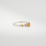 A 925 sterling silver women's solitaire ring featuring a round faceted natural yellow citrine gemstone with side stone accents.