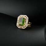 Bague géométrique pour femme en tourmaline verte naturelle et diamants scintillants en argent 925 doré sur satin blanc.