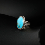 Bague orientale pour femme en turquoise naturelle de Nichapour et argent 925 bordé de torsade sur satin blanc.