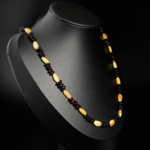 Collier pour adulte en ambre naturel certifié avec perles jaune citron et cognac sur satin blanc.