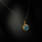 Collier élégant pour femme avec pendentif ovale en aigue-marine naturelle cabochon et argent 925 doré travaillé sur satin blanc.