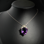 Natural faceted geometric prism purple amethyst pendant necklace with blue topaz accents in two tone 925 silver on white satin