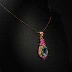 Collier médaillon royal pour femme avec topaze bleue naturelle, rubis et tsavorite en argent 925 plaqué or sur satin blanc.