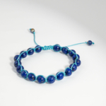 Makramee Armband aus echten 8mm 5A tiefblauen Lapis Lazuli Perlen mit türkisem Band auf weißer Seide.