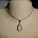 Damen Halskette aus 925 Silber mit facettiertem blau schimmerndem Tropfen Mondstein auf smaragdgrüner Seide.