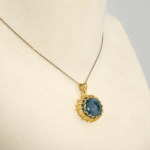 Damen Anhänger Kette aus 925 Silber vergoldet mit echtem ovalem blauem Aquamarin Cabochon in Zierfassung auf Seide.