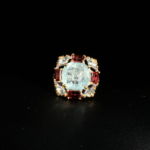 Damen Ring aus 925 Silber mit echtem Aquamarin und Baguette-Granat Halo auf weißer Seide.