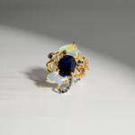 Damen Ring aus 925 Silber im Barockstil mit ovalem blauem Saphir, Opal und Topas auf weißer Seide.