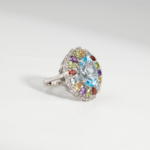 Damen Cocktailring aus 925 Silber mit ovalem blauem Topas, Citrin, Amethyst, Granat und Peridot auf weißer Seide.