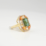 Damen Art-Déco Ring aus 925 Silber vergoldet mit echtem grünem Turmalin, gelbem Saphir und funkelnden Diamanten auf weißer Seide[cite: 41].