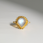 Damen Vintage-Ring aus 925 Silber vergoldet mit blau schimmerndem Tropfen-Mondstein auf weißer Seide.