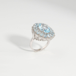Hochwertiger 925 Silber Damenring im majestätischen Rosetten-Design mit echtem ovalem Facetten-Blautopas und Doppel-Halo.