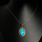 Genuine natural vivid blue Nishapur turquoise gemstone oval pendant yellow gold plated 925 sterling silver chain reflection.