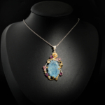 Hand carved rose flower aquamarine pendant necklace with pink tourmalines in two tone 925 silver on white satin.