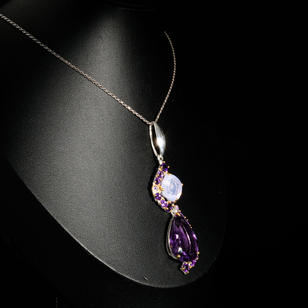Genuine natural purple faceted pear amethyst and lavender quartz gemstone pendant 925 sterling silver chain black background.
