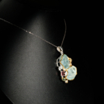 Genuine natural raw aquamarine slice pendant with red tourmaline and blue topaz accents 925 sterling silver black background.