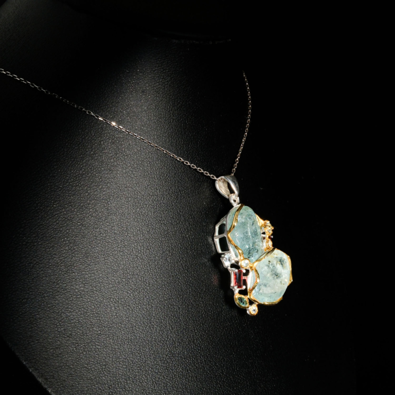 Genuine natural raw aquamarine slice pendant with red tourmaline and blue topaz accents 925 sterling silver black background.