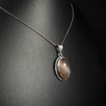 Genuine natural banded grey agate cabochon 925 sterling silver rope frame unisex pendant on black bust profile.