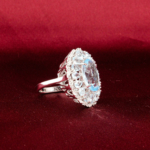 Genuine natural sky blue faceted oval topaz gemstone ring surrounded by double halo cluster 925 sterling silver black background.
