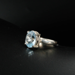 Bague solitaire féminine en argent 925 ornée d'une topaze bleue naturelle taille ovale facettée.