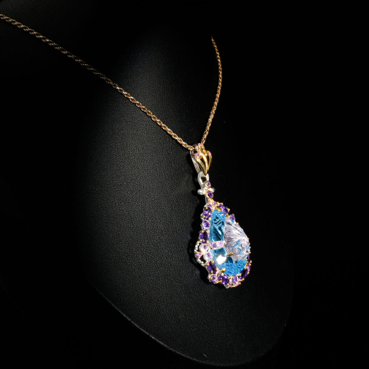 Genuine natural hand carved floral blue topaz pear gemstone pendant with amethyst halo 925 sterling silver black background.